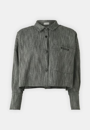 Przycięta szara kurtka z teksturowanym splotem, zapinana na guziki, z dwiema kieszeniami i kwadratową naszywką na lewej piersi.