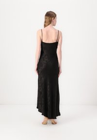 Must mustri maxi kleit õhukeste rihmadega, millel on õrn lillemuster, vormitud bodice ja laienev äär, mis ulatub pahkluuni.