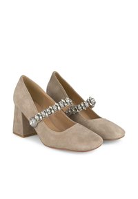 Scarpe beige in suede con tacco a blocco e una larga fascia decorata con gemme trasparenti. Punta arrotondata e superficie liscia.
