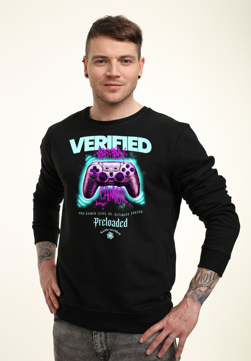 Sudadera negra con cuello redondo que presenta texto colorido y un gráfico de un controlador de videojuego. El material parece suave; diseño informal.