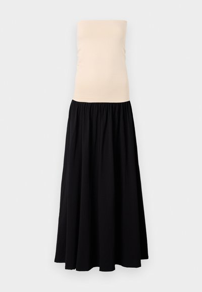 Vestido maxi sin tirantes con un top beige ajustado y una falda negra fluida. Tela suave con cintura fruncida para un caído y movimiento.