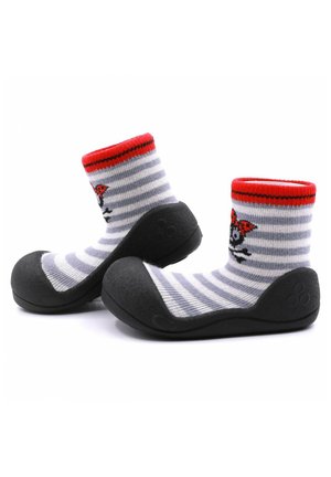 Calcetines rayados en gris y blanco con una parte superior roja, que presentan un diseño de calavera y lazo, unidos a una suela de goma negra para durabilidad.
