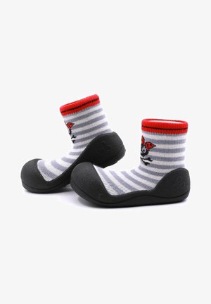 Calcetines rayados en gris y blanco con una parte superior roja, que presentan un diseño de calavera y lazo, unidos a una suela de goma negra para durabilidad.