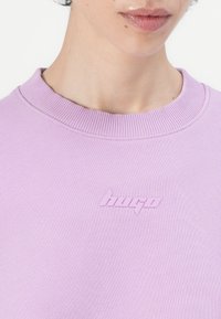 Laventelimittari, jossa on ribbed crew-neck, jolla on tekstuurinen "Hugo"-logo matchaavassa sävyssä rinnassa. Pehmeä kangas.