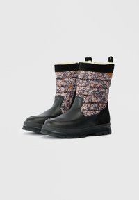 Par de botas de inverno pretas até à meia-coxa com parte superior em tecido acolchoado floral, fecho éclair no lado interior e forro de peles de ovelha visível na parte superior.