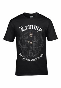 Sort bomuld t-shirt med et grafisk print af en figur i sort tøj, med teksten "Lemmy" og et cirkulært mønster nedenunder, fremhævet af hvide bogstaver.