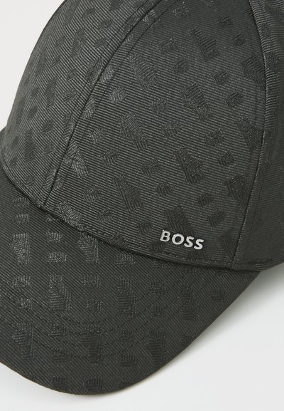 Casquette noire en tissu texturé, avec un motif subtil et un logo "BOSS" argenté à l'avant. Design à visière courbée.