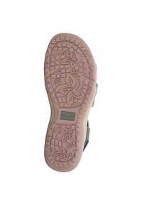 Suela de zapato en goma beige y rosa con un patrón floral, superficie texturizada y elementos de agarre rectangular. Etiqueta del fabricante visible.