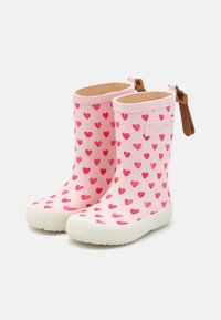 Bottes en caoutchouc roses avec un motif de cœurs dans différentes nuances de rose, semelle texturée et un accent en cuir marron à l'arrière.