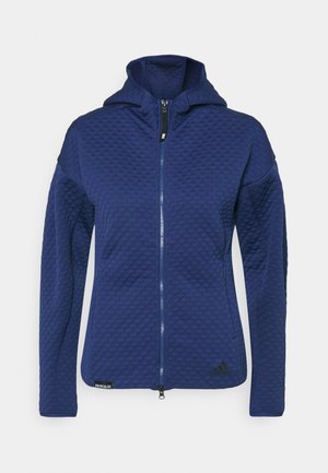 Granatowa pikowana kurtka z kapturem, zamkiem błyskawicznym na całej długości, kieszeniami bocznymi oraz logo Adidas u dołu po prawej stronie z przodu.