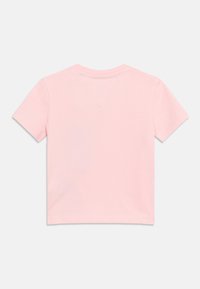 Ροζ ανοιχτό ροζ κοντομάνικο μπλουζάκι για νήπια, απλωμένο επίπεδα, δείχνοντας την πίσω πλευρά με στρογγυλό λαιμόκοψη και εμφανείς λεπτομέρειες ραφής.