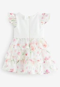 Weißes ärmelloses Kleid mit gestuften floralen Tüllschichten in Pink und Grün, ausgestattet mit einem Reißverschluss auf der Rückseite und einer Schleifendetail am Hals.