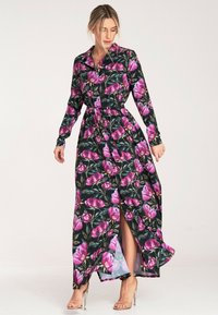 Kwiatowa sukienka maxi z czarnym tłem, różowym i zielonym wzorem kwiatowym, z zapięciem na guziki, długimi rękawami oraz pasek w talii z rozcięciem z przodu.