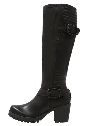Botte noire montante avec une finition en cuir lisse, des panneaux texturés, une sangle à boucle ajustable et un talon chunky avec des profondes rainures.