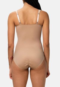 Bodysuit nude con tirantes ajustables delgados, textura suave similar a la piel y detalle sutil de fruncido en la parte posterior. Sin costuras visibles.