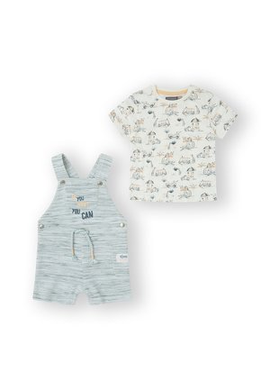 Pichones de mezclilla gris claro con tirantes ajustables, que presentan un lema bordado. Acompañados de una camiseta color crema con estampados de animales.