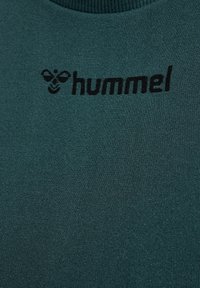 Groen geribd stoffen sweatshirt met een zwart "hummel" logo en bijenontwerp op de bovenste linkerzijde van de borst.
