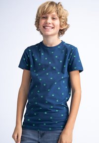 Tricou bleumarin cu mânecă scurtă, decorat cu mici motive verzi pe material. Fabricat dintr-un material moale din bumbac, având guler rotund.