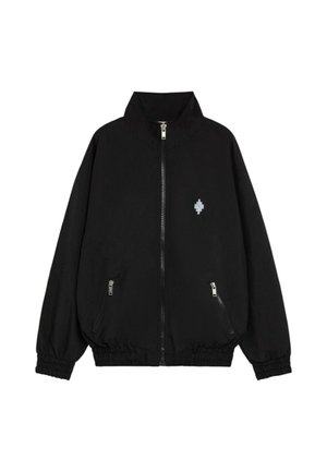 Giacca nera leggera con zip frontale, collo alto, polsini elasticizzati e due tasche laterali. Presenta un piccolo logo sul petto.