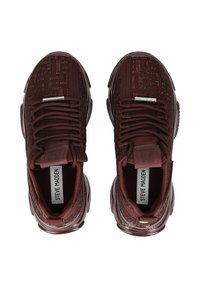 Sneakers bordeaux con tomaia in tessuto testurizzato, punta arrotondata e sistema di lacci. Presentano il marchio sulla linguetta e sul tallone. Suola in gomma.