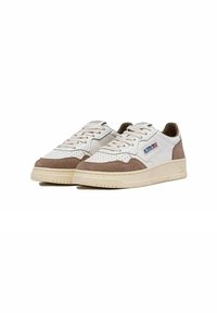 Sneaker con una toma in pelle bianca e beige, dettagli in suede marrone, dettagli perforati e una suola in gomma bianca. Presenta il logo del marchio sul lato.
