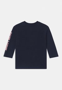 Marinblus med lång ärm och ribbad rund halsringning; har "RALPH LAUREN" i röd och vit text längs vänster ärm. Mjuk bomullstyg.