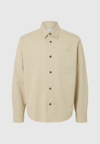 Camicia beige con bottoni realizzata in tessuto di cotone. Caratterizzata da un colletto classico, maniche lunghe, una tasca sul petto e bottoni marroni. Tessuto liscio.