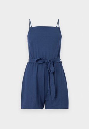 Combinaison courte sans manches bleu marine avec de fines bretelles, un décolleté droit et une ceinture en tissu nouée à la taille.
