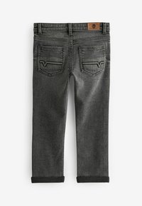 Jeans in denim grigio con una texture liscia, gamba affusolata, orli arrotolati, due tasche posteriori e un'etichetta in pelle marrone in vita.