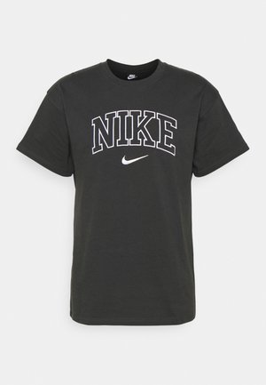 T-shirt en coton noir à manches courtes avec texte Nike blanc et logo swoosh centrés sur la poitrine.