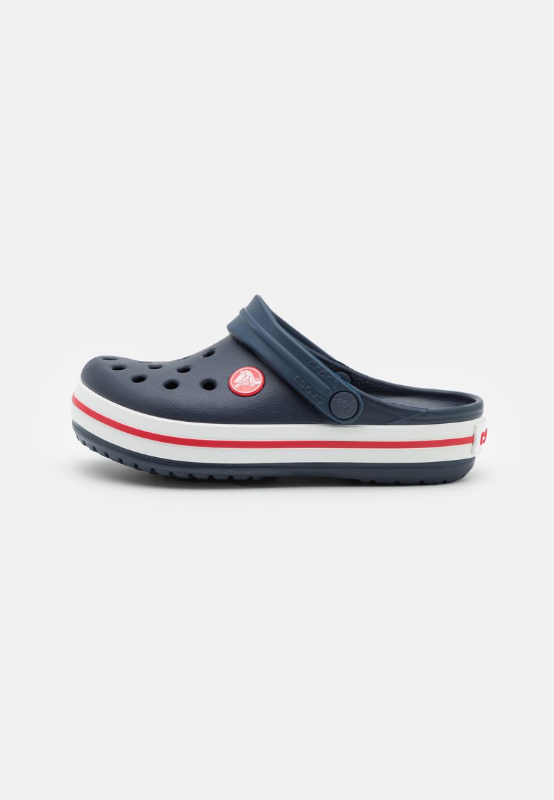 Zoccolo blu navy realizzato in materiale leggero con fori di ventilazione, caratterizzato da una suola a righe rosse e bianche e una tracolla posteriore per supporto.