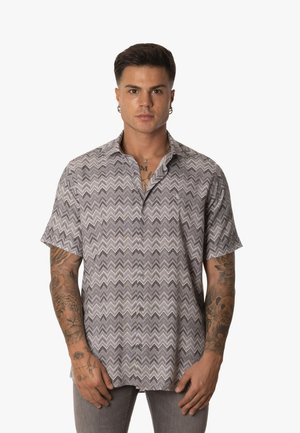 Camisa de botones de manga corta en gris con patrón de zigzag, que cuenta con un corte relajado y un sutil logo bordado en el pecho.