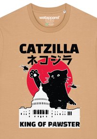 Beige katoenen T-shirt met een grafisch ontwerp van een zwarte kat tegen een rode cirkel, silhouet van het Capitool van de VS, en de tekst "CATZILLA KING OF PAWSTER."