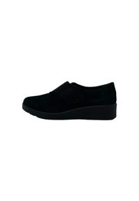 Scarpa in suede nera con punta tondeggiante, cinturino elastico e dettagli texturizzati. Presenta una suola in gomma a zeppa bassa per stabilità.
