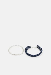 Bracelet en corde marine avec des accents multicolores et un détail en nœud à côté d'un bracelet en chaîne argenté avec une fermeture à fermoir.