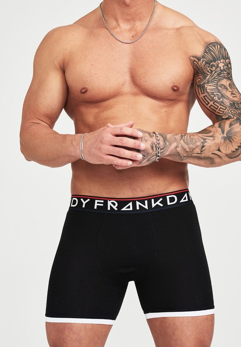 Schwarze Boxershorts für Herren mit weißen Akzenten. Der Gummibund zeigt ein Markenlogo in kontrastierenden Farben. Weicher, dehnbarer Stoff.
