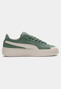 Green leather sneakers with a cream-colored platform sole, textured accents, and a rounded toe. Features a classic lace-up design.