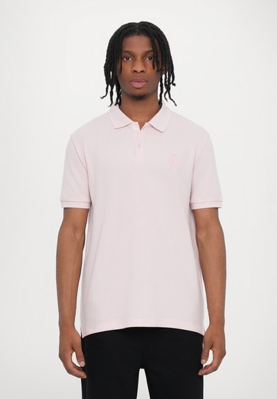Camisa polo rosa con cuello, mangas cortas y detalle de logo bordado en el pecho. Tela suave con un corte relajado.