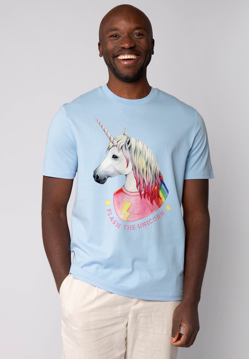 Lichtblauwe T-shirt met een eenhoornafbeelding met een regenboog manen, een bliksemschicht, en de tekst "FLASH THE UNICORN" in een cirkelontwerp.