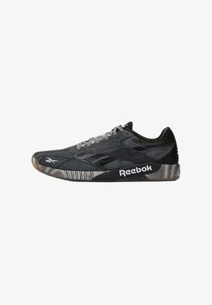 Zwart-grijze Reebok sneaker met een patroon op de zool, een bovenwerk van mesh en een wit Reebok-logo aan de zijkant en de neus.