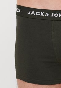 Dunkelgrüne Boxershorts aus Baumwolle, die eine enge Passform bieten, sowie einen kontrastierenden elastischen Bund mit dem Markennamen "JACK & JONES."