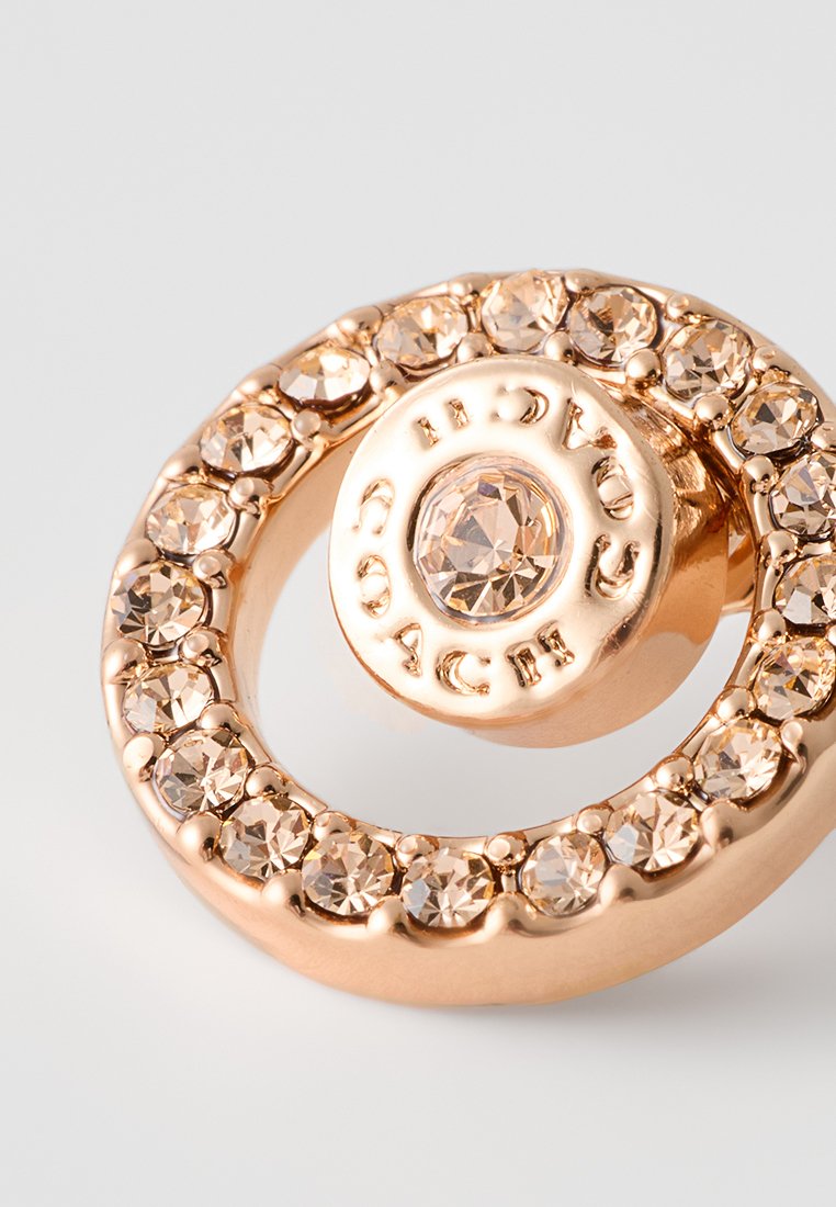 Goldfarbene kreisförmige Ohrringe mit einem zentralen Kunststein, umgeben von kleineren facettierten Kristallen, glatter Metalloberfläche und geprägtem Branding.