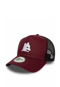 Gorra marrón con trasero de malla negra, con un logo de cabeza de lobo blanco. Correa ajustable con una etiqueta de marca redonda en la parte frontal.