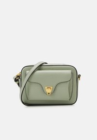 Zielona skórzana torebka na ramię z teksturowaną powierzchnią, kieszenią pod klapą, złotymi elementami metalowymi i czarnym wykończeniem, z regulowanym paskiem.