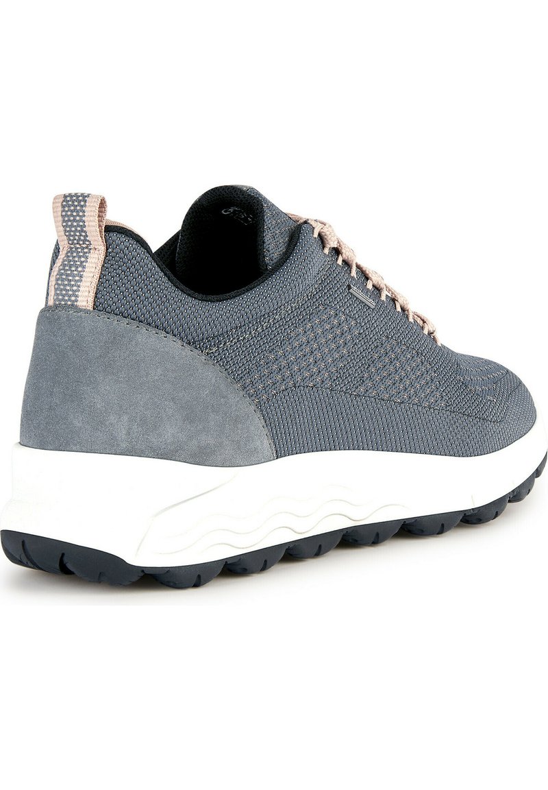 Scarpa da ginnastica grigia con tomaia in mesh testurizzato, dettagli in suede, lacci beige e suola bianca con motivo a onde.