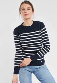 Maglione a righe blu navy e bianco con scollo rotondo, polsini a coste e tre dettagli con bottoni sulla spalla. Materiale in misto cotone.