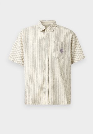 Cameria a maniche corte con bottoni di colore crema con strisce verticali scure. Presenta una tasca con un design ricamato viola. Tessuto testurizzato.