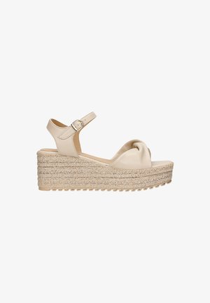 Sandales compensées en cuir beige avec un dessus noué, une bride de cheville ajustable et une semelle intermédiaire en jute tissé présentant une surface texturée.