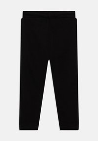 Svarta leggings gjorda av mjukt, elastiskt material. Har ett elastiskt midjeband, full längd och en slät yta utan synliga mönster.