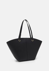Sac fourre-tout en cuir noir avec une forme structurée et angulaire. Dispose de deux longues poignées et de quincaillerie dorée aux points de fixation.